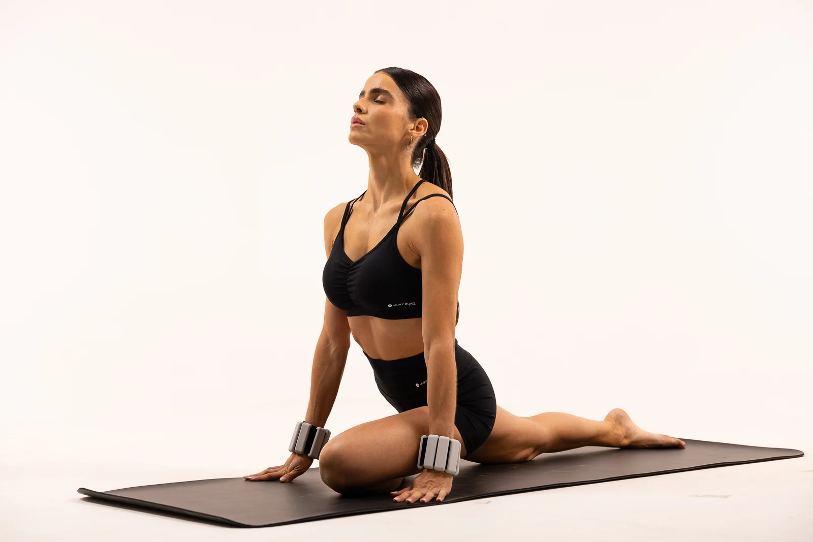 Aluna em exercício de Hot Pilates com caneleiras de peso